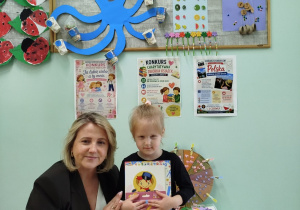 Pani Wicedyrektor wręcza nagrodę i dyplom dziewczynce
