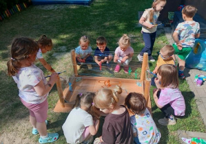 Dzieci bawią się poprzez sztukę w ogródku przedszkolnym.