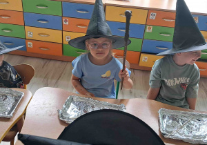 Dzieci w czapkach czarodziejskich przy stoliku