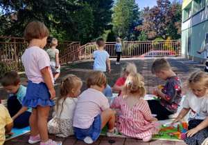 Przedszkolaki bawią się na tarasie.