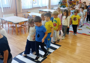 Przedszkolaki przechodzą przez przejście dla pieszych.