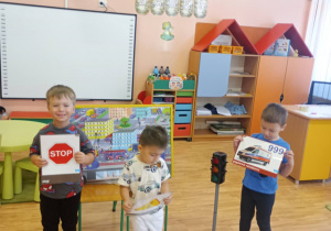 Chłopcy trzymają tabliczki ze znakami.