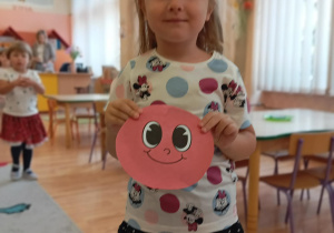Dziewczynka w koszulce w kropki odnalazła ukrytą kropkę.
