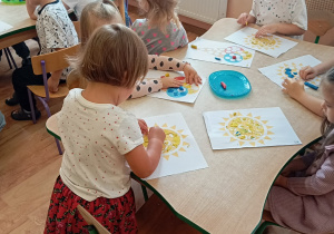 Dziewczynki wykonują pracę plastyczną.