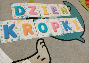 Na dywanie leży napis Dzień Kropki.