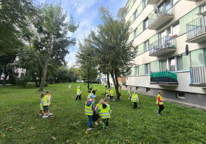 Dzieci sprzątają tereny zielone.