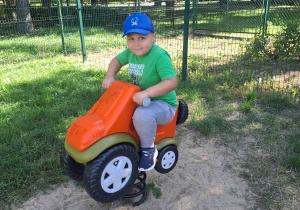 Chłopiec bawi się na bujanym motorku