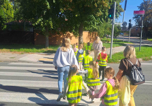 Dzieci prawidłowo przekraczają ulicę oznakowaną sygnalizatorem