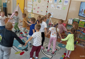 Dzieci tańczą na dywanie