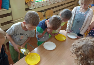Dzieci eksperymentują z olejem i barwnikami tworzą mozaikę