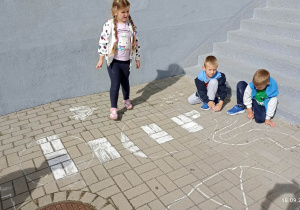Dzieci rysują kredą przejście dla pieszych