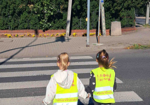 Dzieci przechodzą przez przejście dla pieszych z sygnalizacją