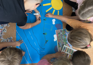 grupa przedszkolaków wspólnie wykonuje prace plastyczną