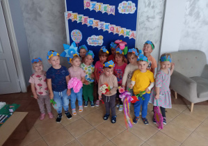 Grupa dzieci stoi przy napisie Dzień Przedszkolaka.