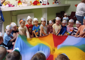 Przedszkolaki uczestniczą w zabawach z chustą animacyjną.