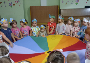 Chłopcy i dziewczynki stoją dookoła chusty animacyjnej.