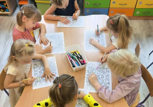 Dzieci przy stoliku kolorują