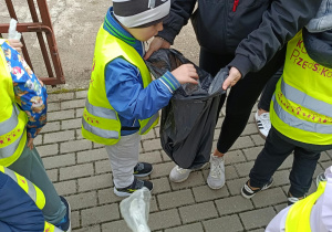 Dzieci wrzucają śmieci do worków