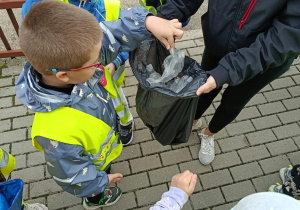 Dzieci wrzucają śmieci do worków