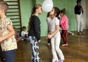 Dzieci biorą udział w zabawie ruchowej z balonami