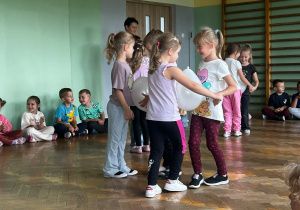 Dzieci biorą udział w zabawie ruchowej z balonami