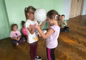 Dzieci biorą udział w zabawie ruchowej z balonami