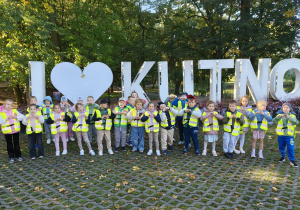 Grupa dzieci stoi przed napisem I love Kutno