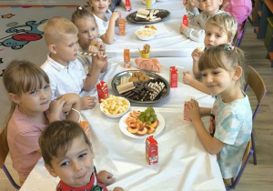 Dzieci biorą udział w poczęstunku.