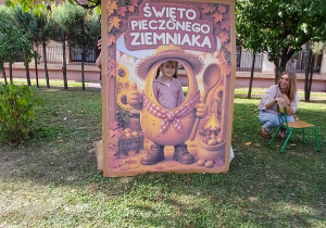 Dziecko pozuje w dekoracyjnej fotościance z motywem pieczonego ziemniaka