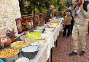 Rodziny korzystają z przygotowanego stołu pełnego sałatek