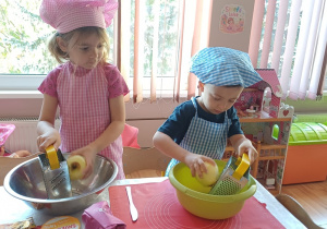 Dzieci ścierają jabłka na tarce