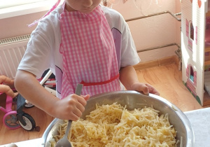 Dziewczynka miesza jabłka na ciasto