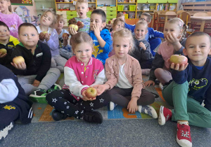 Dzieci oglądają, wąchają i opowiadają o jabłkach