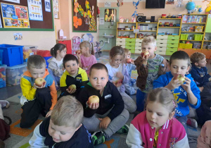 Dzieci oglądają, wąchają i opowiadają o jabłkach