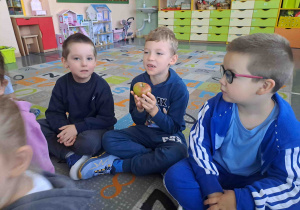 Dzieci oglądają, wąchają i opowiadają o jabłkach