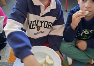 Dzieci częstują się jabłuszkami pokrojonymi w plasterki