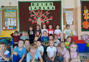 Pamiątkowa fotografia grupowa pod wykonanym drzewem jabłoni