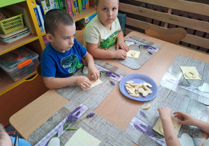 Dzieci przygotowują rogaliki z ciasta francuskiego i jabłek