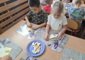 Dzieci przygotowują rogaliki z ciasta francuskiego i jabłek