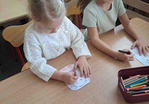 Dzieci wykonują papierowe sylwety postaci