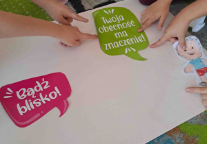 Dzieci wskazują palcami wybrane hasła na plakatach