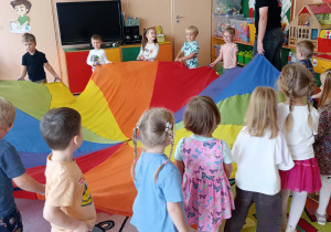 Chłopcy i dziewczynki bawią się z animatorem.