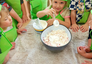 Dziewczynka dodaje jogurt grecki.