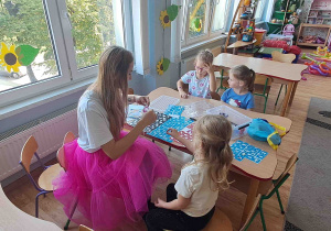 Animatorka wykonuje dzieciom brokatowe tatuaże