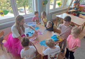 Animatorka wykonuje dzieciom brokatowe tatuaże
