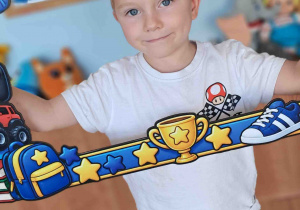 Chłopiec pozuje do zdjęcia w okolicznościowej ramce