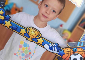 Chłopiec pozuje do zdjęcia w okolicznościowej ramce