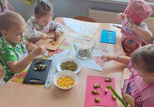 Dzieci kroją na deseczkach warzywa na sałatki