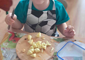 Dzieci kroją na deseczkach warzywa na sałatki