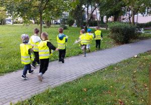 Dzieci szukają śmieci na trawniku